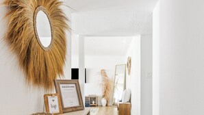 Un intérieur moderne avec une console en bois, un miroir et des certificats encadrés.