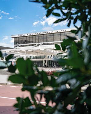 L’extérieur du Georgia World Congress Center présente une architecture moderne, avec de grandes fenêtres en verre et un espace d’entrée abrité.