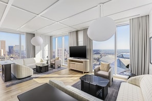 A modern hotel room with a large TV, comfortable seating, a city view, and a large window. - Signia By Hilton Atlanta Georgia World Congress Center (Atlanta)