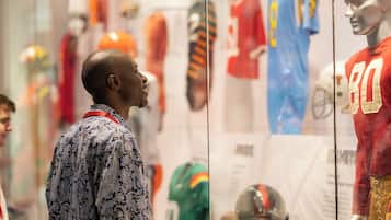 A man observing sports memorabilia in a display case.
