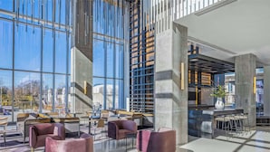 A modern interior with seating areas, large windows, and a bar. - Signia By Hilton Atlanta Georgia World Congress Center (Atlanta)