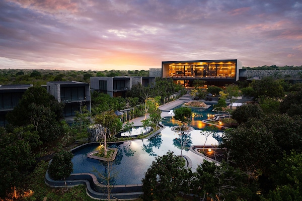 Een buitenzwembad, parasols bij het zwembad en ligstoelen