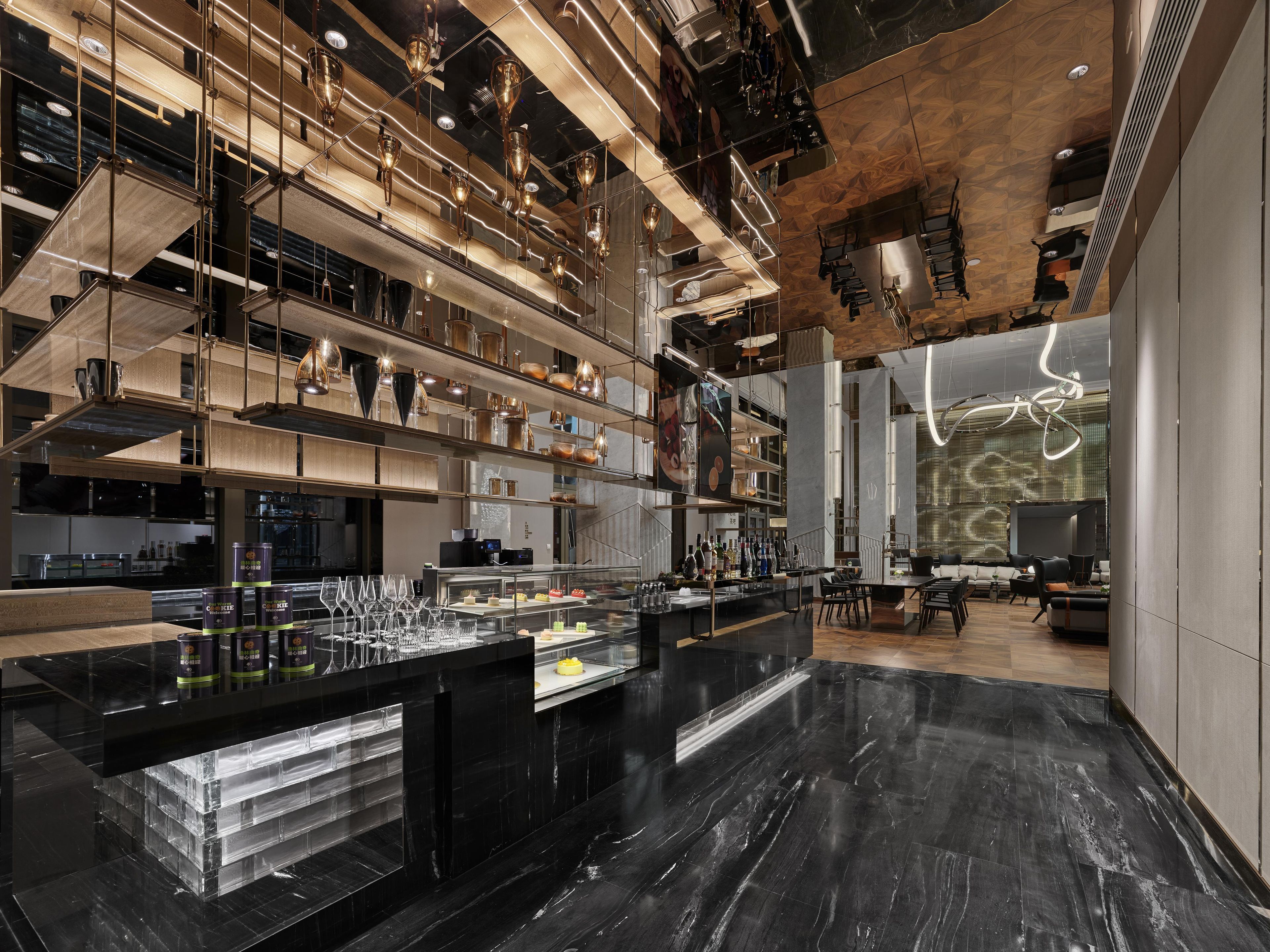 Un interior modern amb una zona de bar central, diferents nivells d'seients i un disseny de sostre singular.