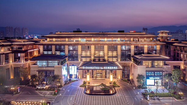 A modern hotel with a prominent entrance, multiple floors, and a well-lit facade. - Doubletree By Hilton Cangnan (Wenzhou)
