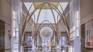A spacious lobby with a high ceiling, large chandelier, and modern furnishings. - Doubletree By Hilton Cangnan (Wenzhou)