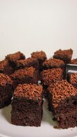Un plato de brownies cubiertos de grageas de chocolate.