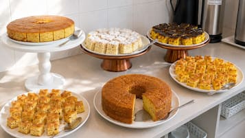 A kitchen counter with various baked goods displayed on plates and stands.