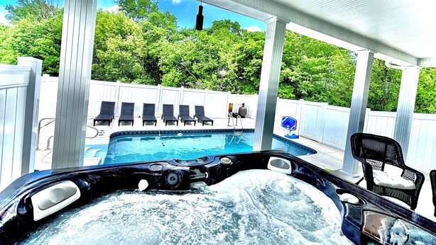 A hot tub with a view of a backyard pool and lounge chairs. - Bourbon Trail POOL Zone! HotTub! PoolTable! PingPong! GoldenTee! BigYard! PETS! (Springfield)