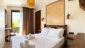 A hotel room with a large bed, a wooden nightstand, a desk, and a chair. - Nuriye Alacati (Cesme)