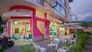 A brightly lit storefront with outdoor seating and a colorful mural. - Hotel Payanito (Chanchamayo)