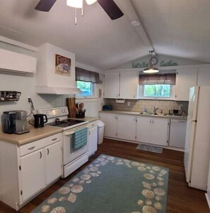 Kitchen features a central island, coffee maker, and window above the sink.