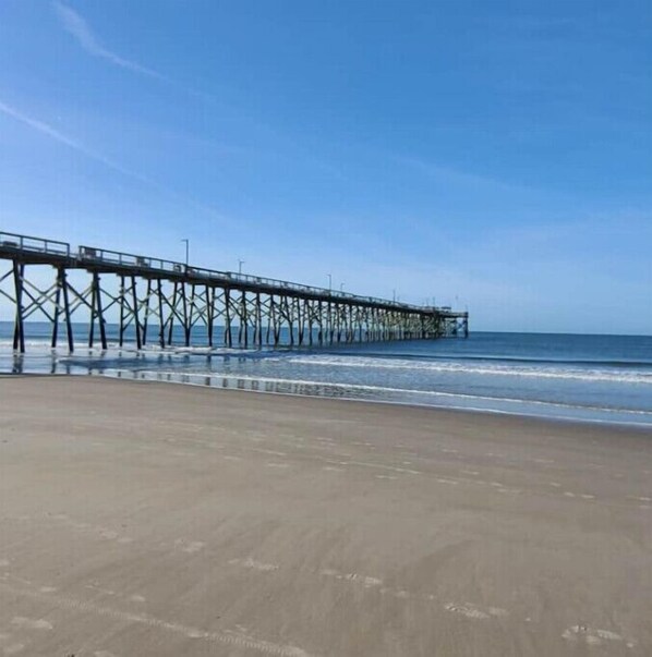 Stroll along the long pier, where gentle waves meet the shore.