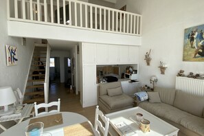 Un espace de vie de style industriel, avec un escalier, un coin repas et une cuisine.