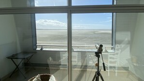 A room with a large window, a tripod, and a small table. - Les Pieds dans l'Eau, bay view for 6 people (Le Crotoy)