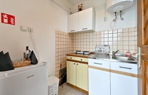 Kitchen features an oven, sink, and refrigerator, along with a range hood and dish rack.