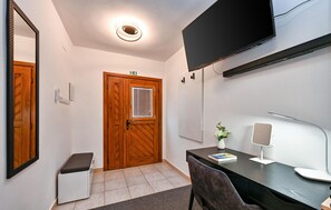 Cozy retreat with a wooden door, flat-screen TV, and comfortable seating area.