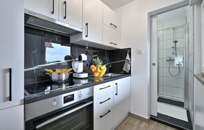 Enjoy cooking in this kitchen with an oven, stainless steel range hood, and coffee maker.