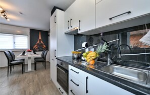 Enjoy a stylish dining experience with a view of the Eiffel Tower from this kitchen's large window.