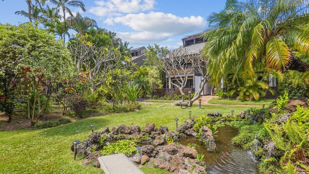 A tropical garden with a pond, palm trees, and a modern house. - LOW August   rates  A/C-Free Parking-No Resort Fees (Kihei)