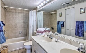 Een badkamer met een bad, toilet en wastafel.