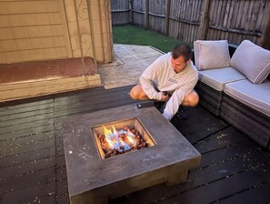 Relax by the fire pit in this outdoor space, surrounded by a comfortable sofa and bench.