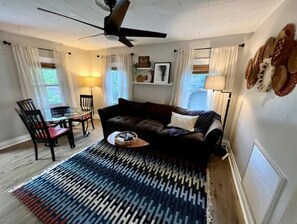Relax in this stylish living room with a sofa, coffee table, and dining area.