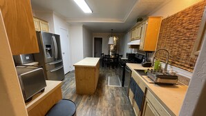 Una cocina moderna con armarios de madera, electrodomésticos de acero inoxidable y una isla central.