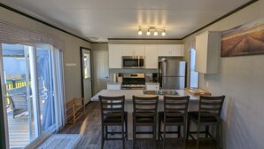 A modern kitchen with white cabinets, stainless steel appliances, and a central island with bar stools. - Paradise in Niagara-on-the-lakes at Vine Ridge Resorts.  (Niagara-on-the-Lake)