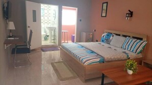 Un dormitorio con cama, mesita de noche y un pequeño escritorio con silla.
