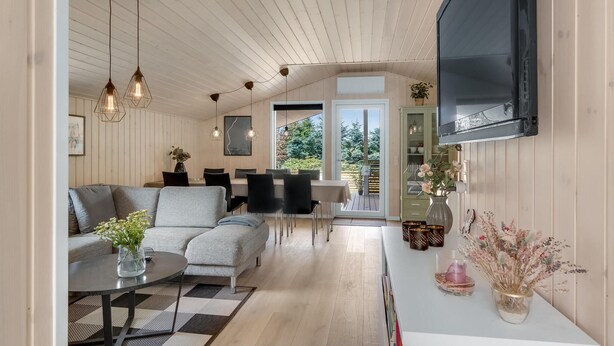 Et moderne interiør med spiseplads, sofa og fjernsyn.