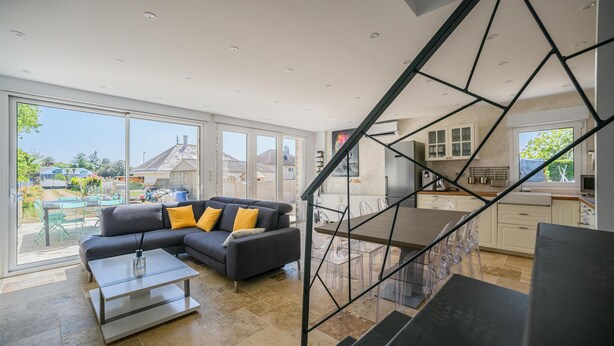 A modern living room with a grey sofa, yellow cushions, and a glass coffee table.