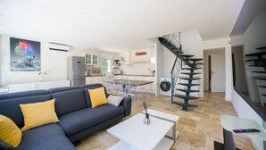 A modern living room with a sofa, coffee table, and a kitchen area in the background.