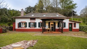 Una casa con patio, zona pranzo e un piccolo giardino.