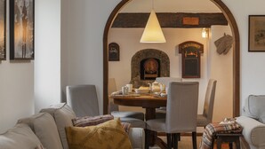 Zona pranzo con un tavolo rotondo, sedie e una lampada a sospensione.