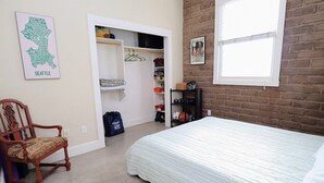Une chambre à coucher avec un lit, une chaise, une armoire et une fenêtre.