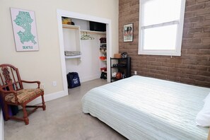 A bedroom with a bed, a chair, a closet, and a window. - Barrio Viejo, Charming Historic Downtown Home (Tucson)
