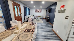 A modern living room with a patterned rug, a sofa set, and a decorative wall piece.