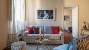 A living room with a sofa, a coffee table, and a framed artwork on the wall.