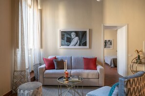 Een woonkamer met een bank, een salontafel en een kunstwerk in een lijst aan de muur.