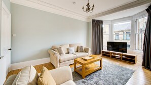 A living room with a sofa, coffee table, and TV stand.