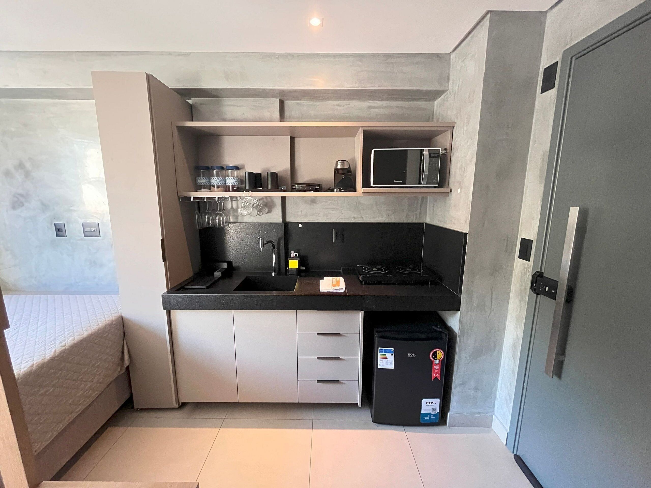 Una cocina compacta con microondas, estufa y refrigerador.
