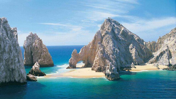 A coastal landscape with rocky formations and a sandy beach. - New Remodel / Spanish Chic Suite on the Cabo Marina (Cabo San Lucas)