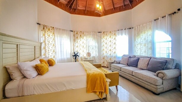 Un dormitorio con una cama, un sofá y una mesita de noche.