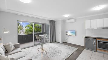 Een modern appartement met een woonkamer, keuken en balkon.