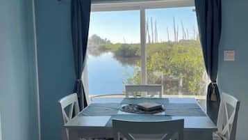 Enjoy meals with a view of the serene water and lush surroundings from this dining area.