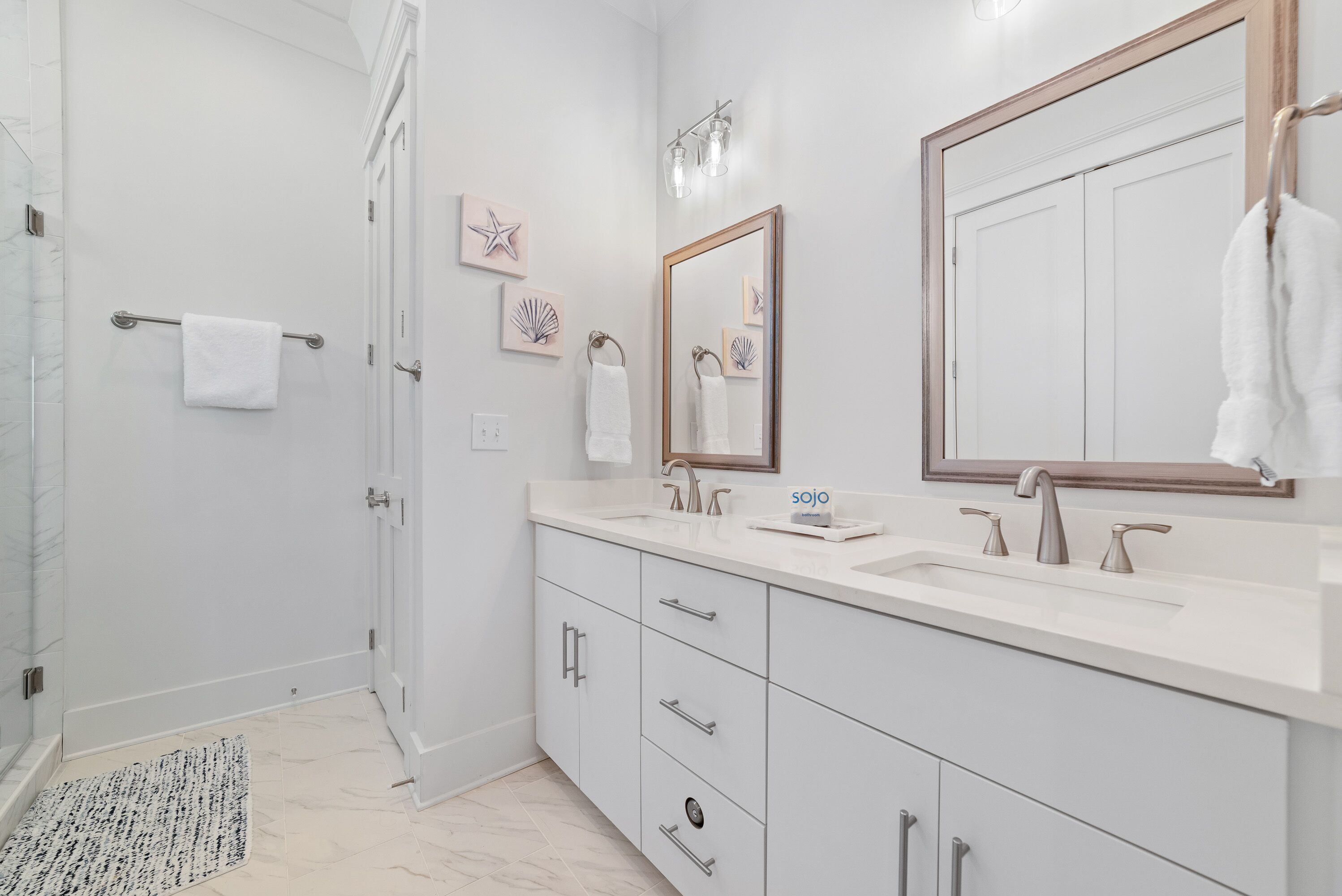 Un bagno moderno con doccia a filo pavimento, uno specchio grande e un mobile lavabo.