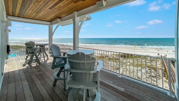 A wooden deck with Adirondack chairs and a table overlooking a beach. - BEACHFRONT, LUXURY HOUSE, PRIVATE POOL! (Orange Beach)