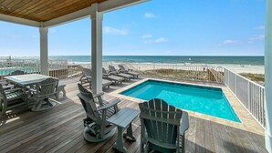 A wooden deck with a pool, lounge chairs, and a view of the ocean. - BEACHFRONT, LUXURY HOUSE, PRIVATE POOL! (Orange Beach)
