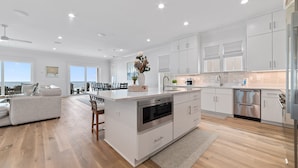 A modern kitchen with white cabinetry, stainless steel appliances, and a central island. - BEACHFRONT, LUXURY HOUSE, PRIVATE POOL! (Orange Beach)