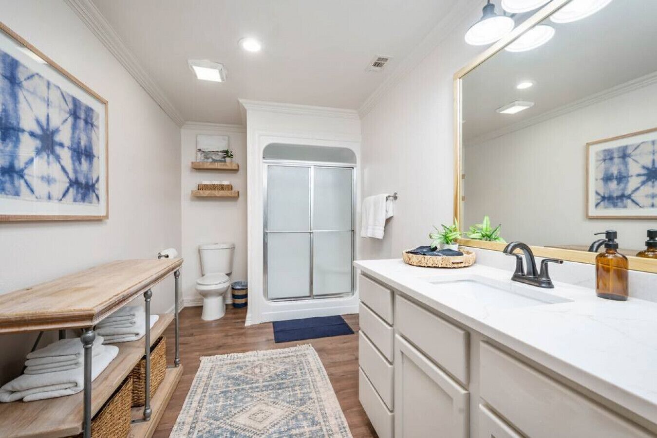A modern bathroom with a shower, toilet, and vanity.